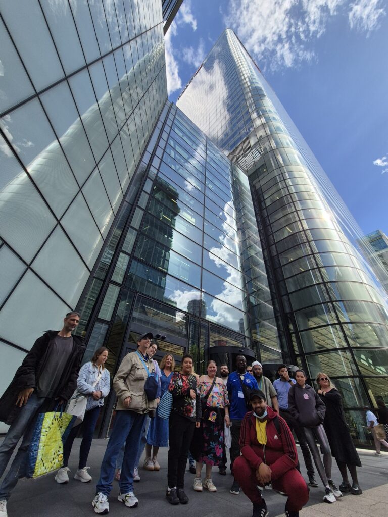 a group of people in front of the HSBC Tower in Canary Wharf