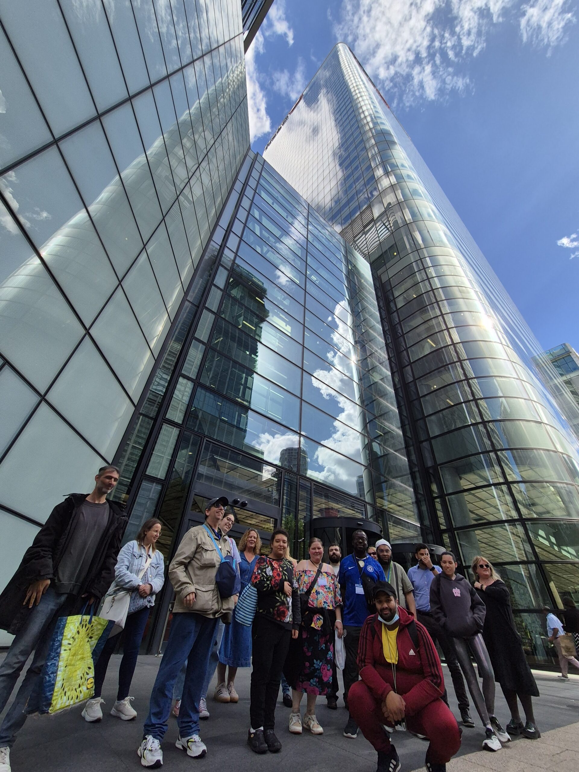 group of people in front of the HSBC Tower in Canary Wharf