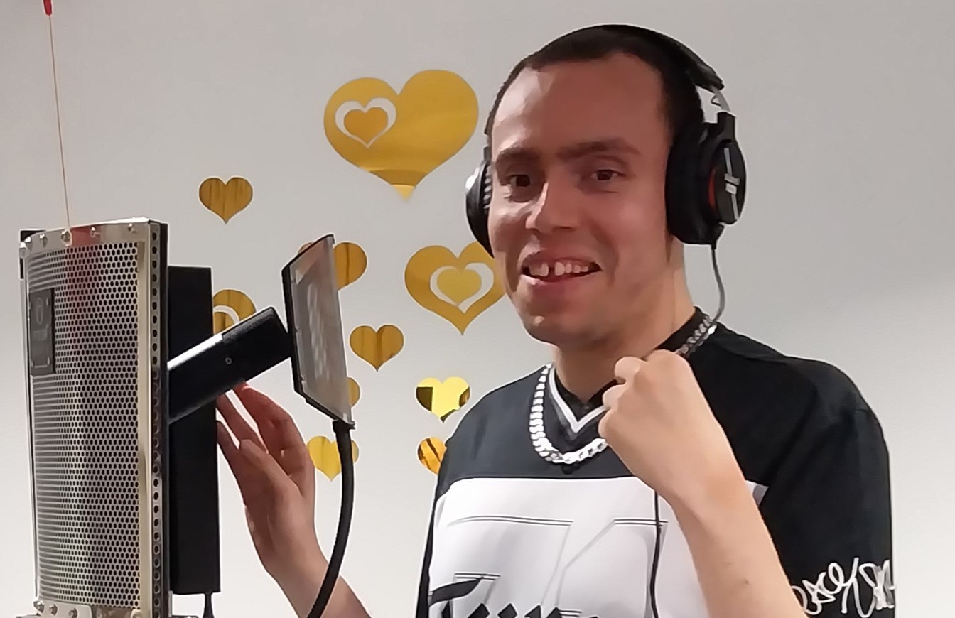 Audie is wearing headphones and in front of a microphone