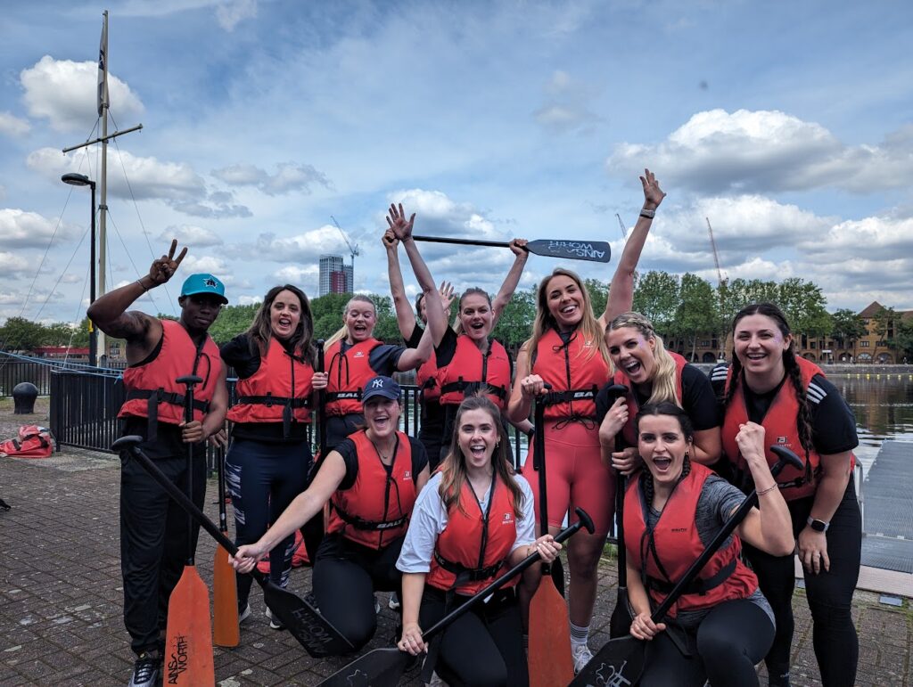 Team from Dragon Boart race holding oars in the air and cheering