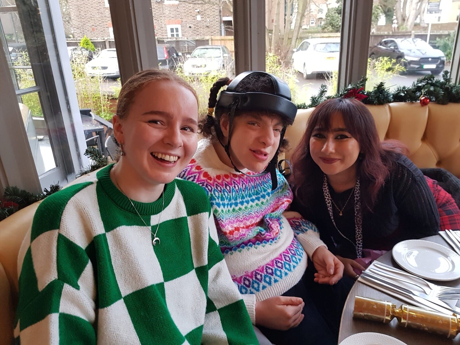 Three women seated and smiling at the camera
