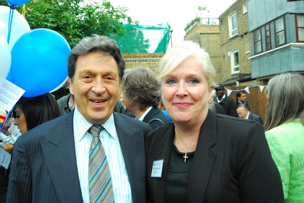 Two people standing outside next to balloons