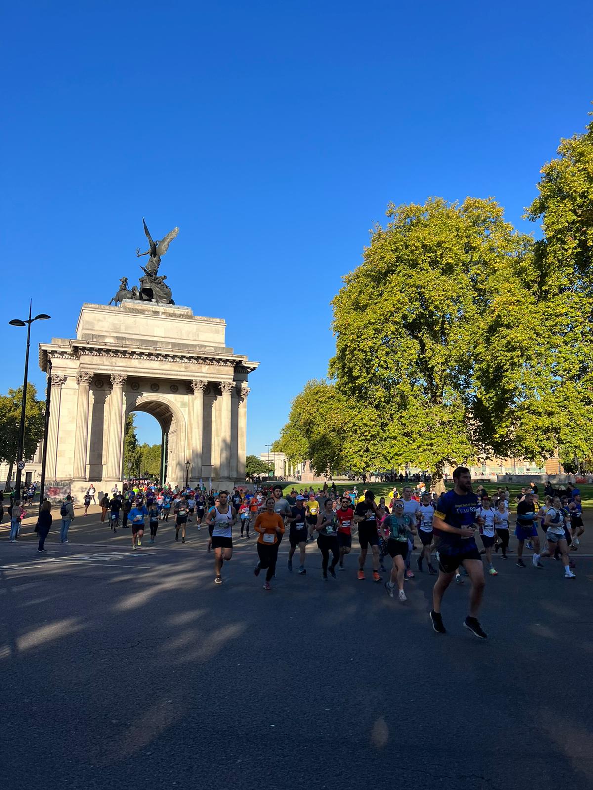 Large group of runners passing Wellington Arch during a road race in London.