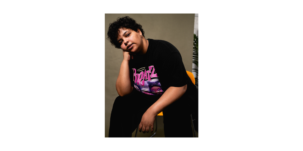 A woman seated and looking at the camera