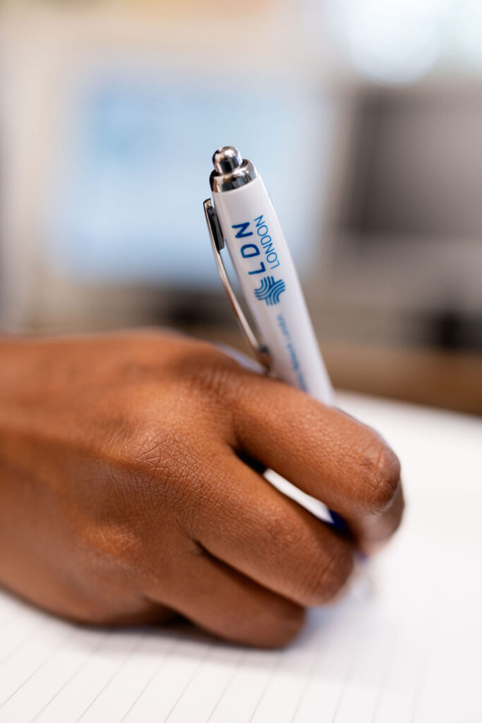 A hand holding an LDN London branded pen