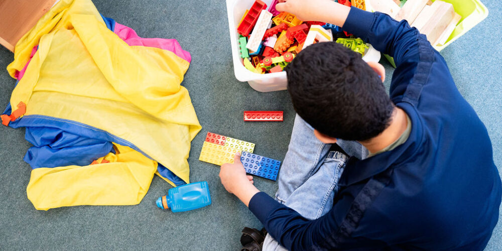 Young person shot from above playing with lego