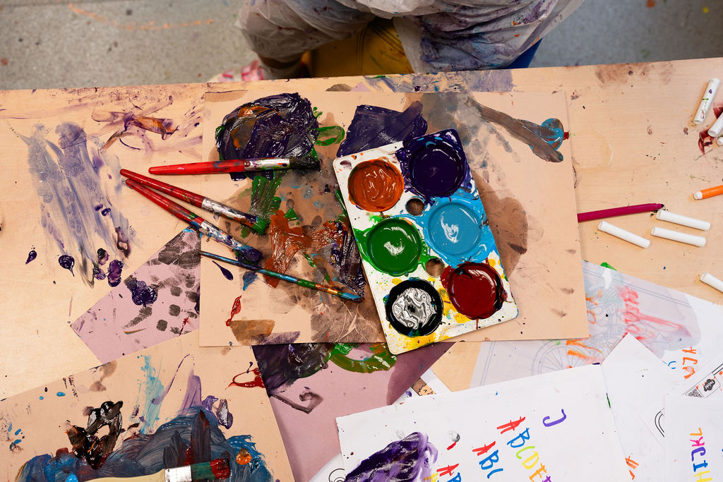 A table full of messy paint pots