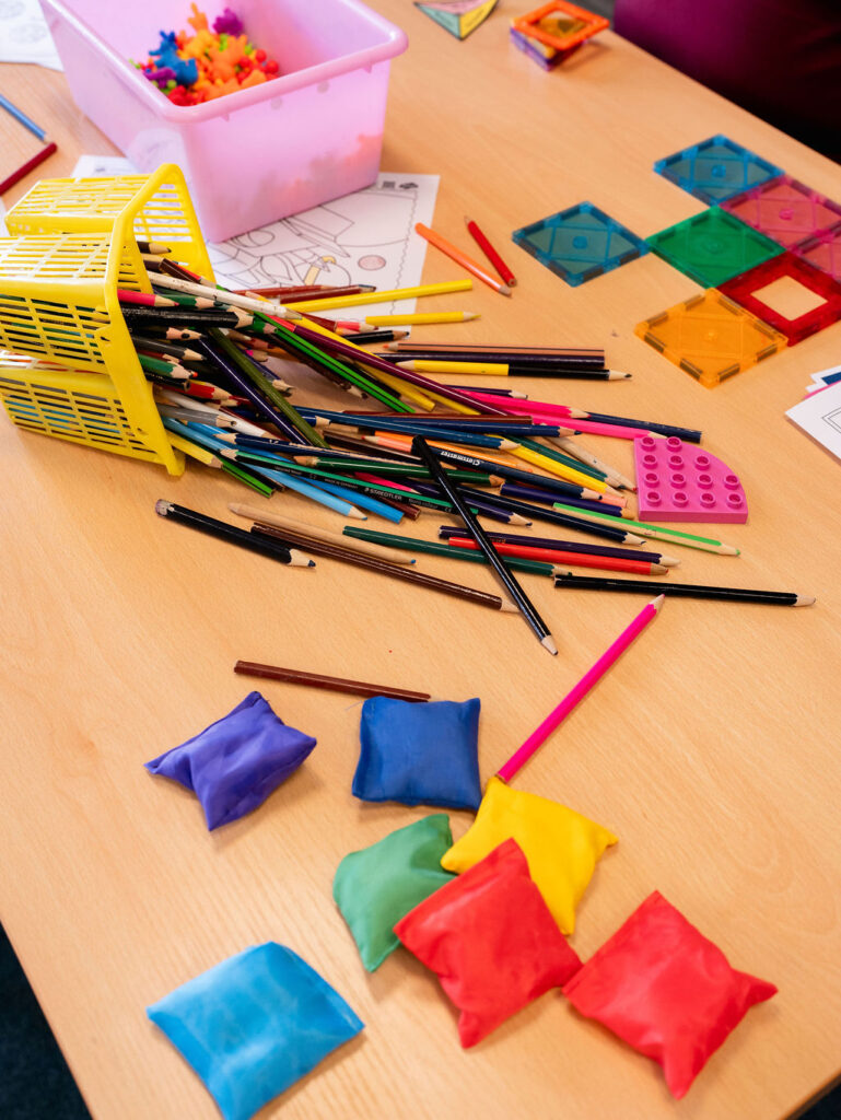 A table with pencils and sensory activites laid out