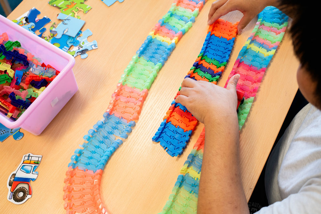 A young person creating train tracks