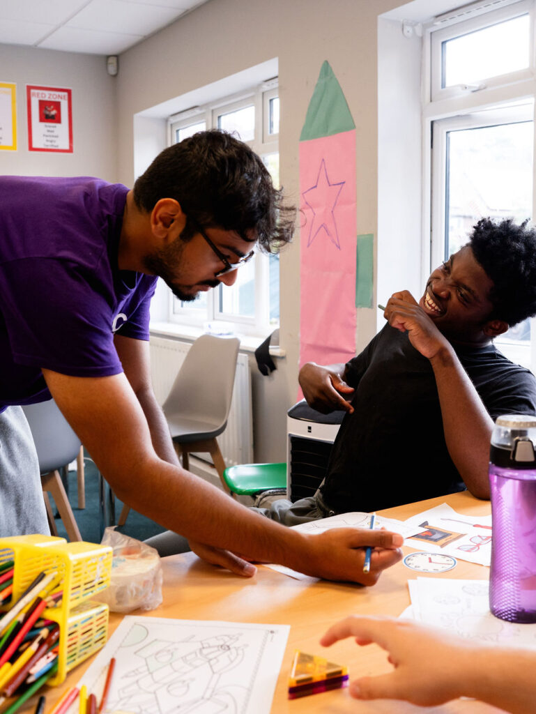 A young person and support worker interacting and laughing