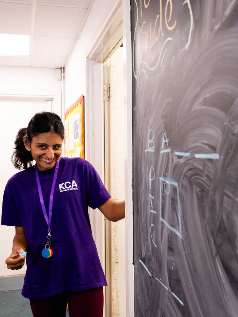 A support worker playing hangman on the board and laughing