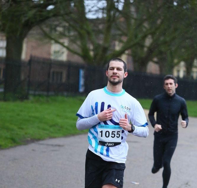 Runner wearing a LDN London running top participating in a city running event.