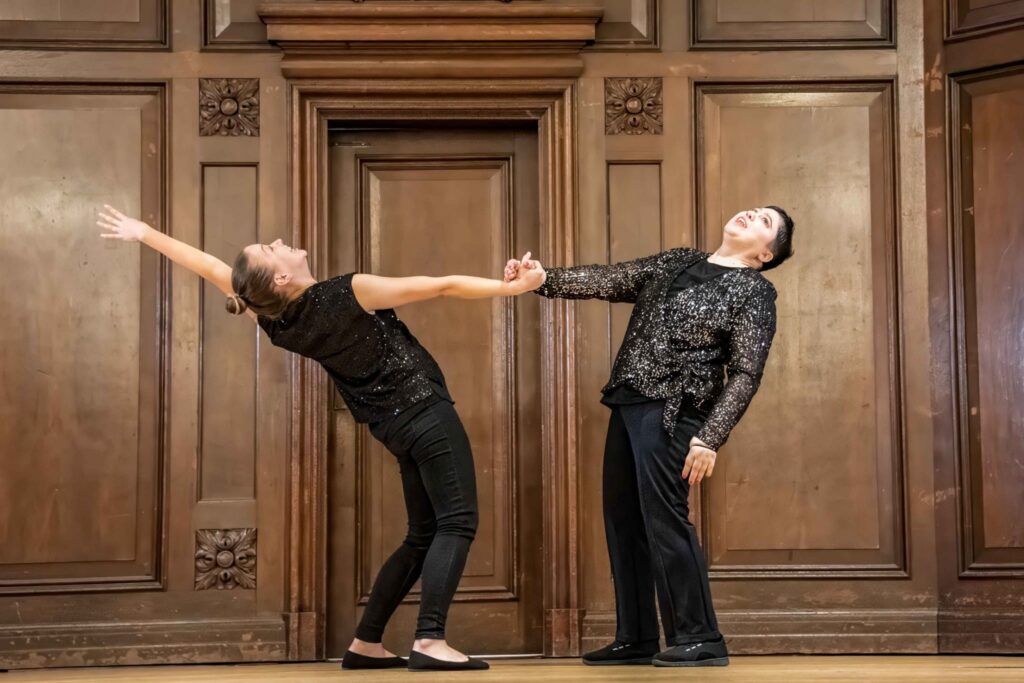 Two dancers performing a contemporary dance routine on stage.