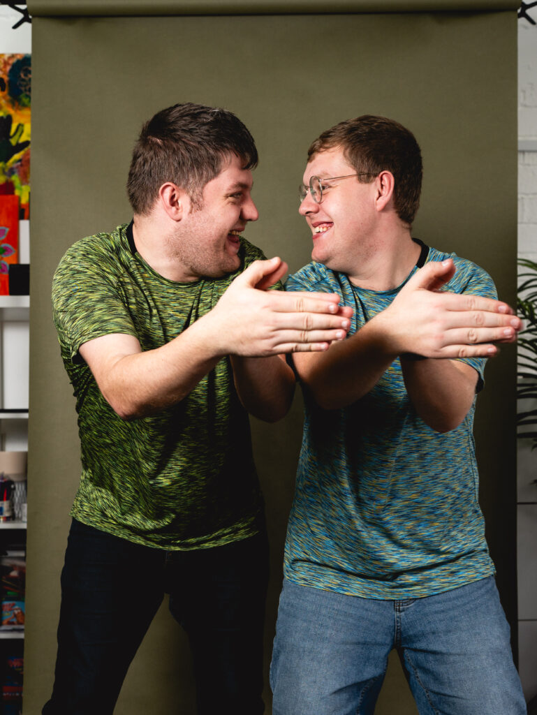 Two brothers dancing with their hands together and looking at each other