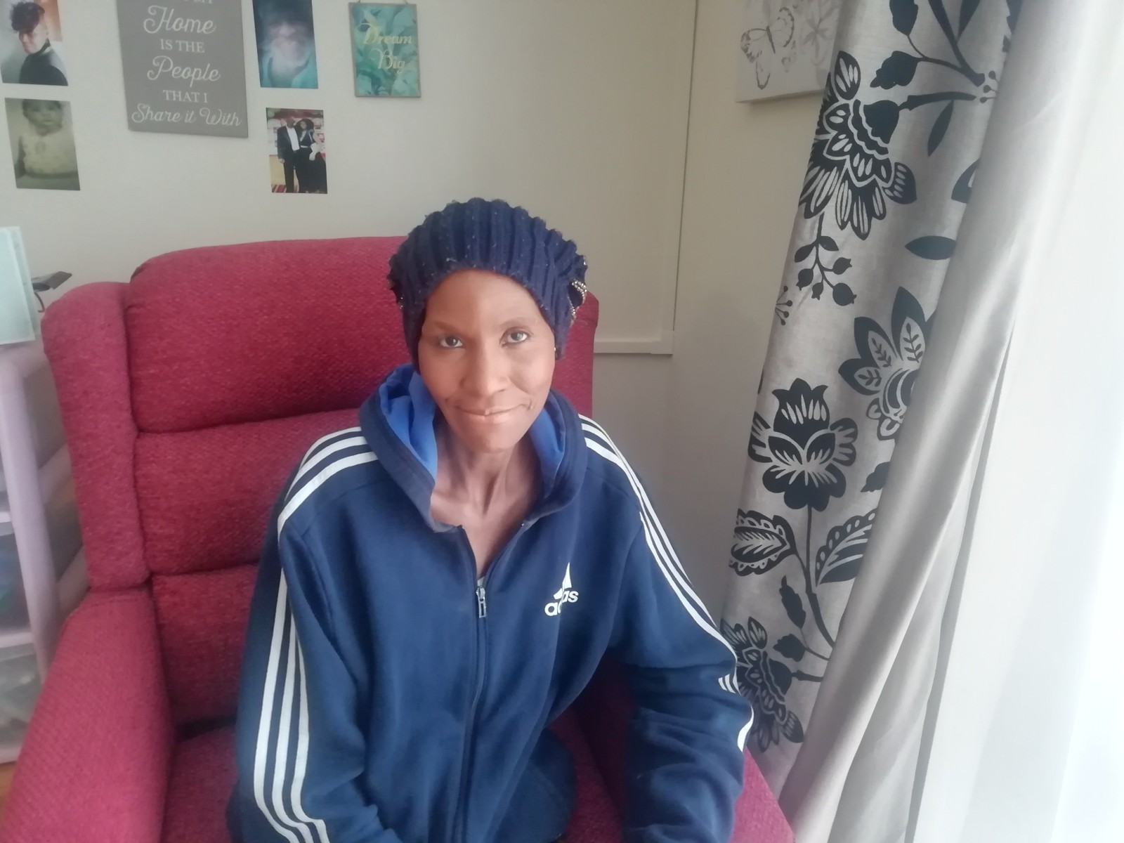 A woman is seated and looking at the camera