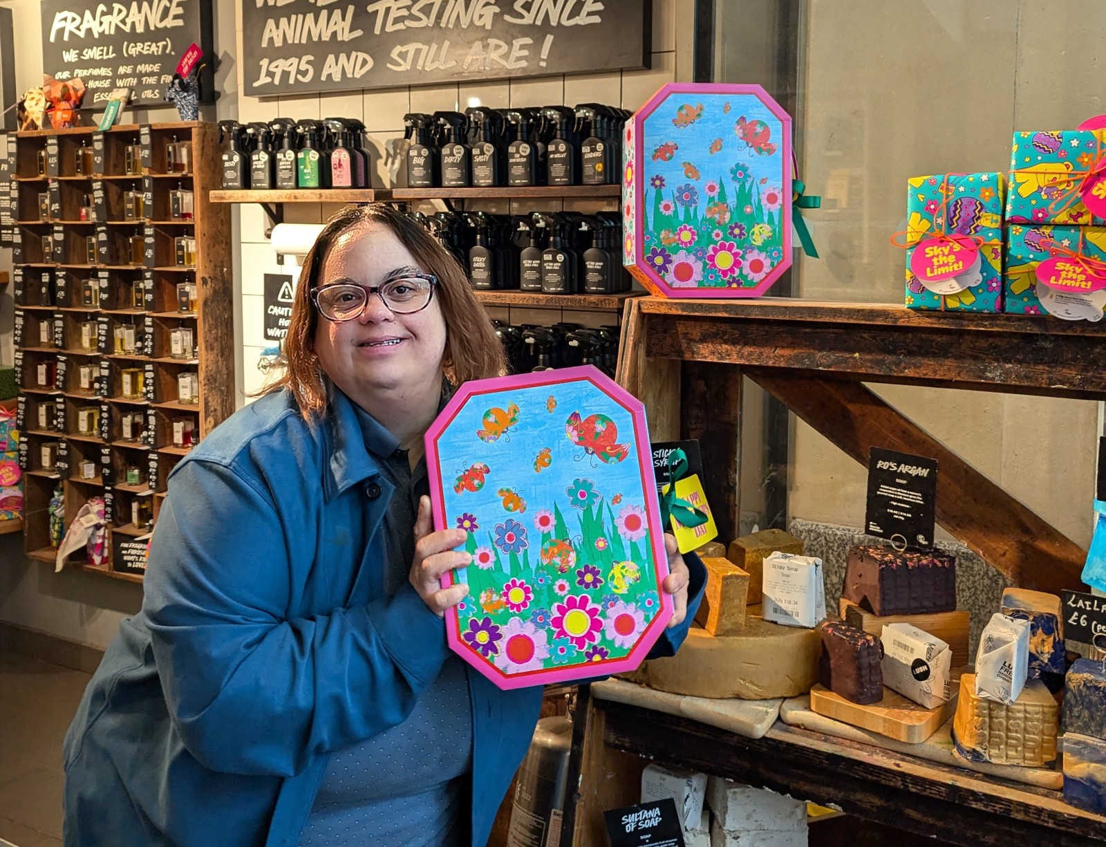 A woman holds a colourful gift box in a shop