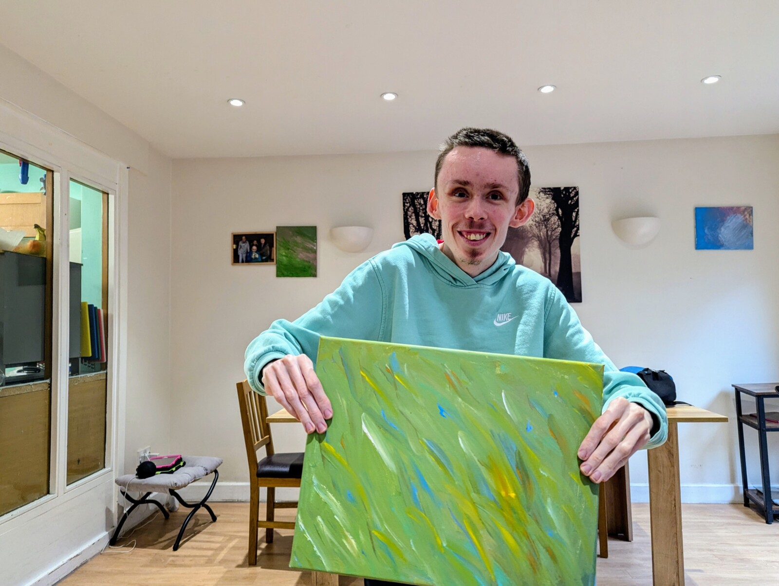 A man holding a colourful piece of art