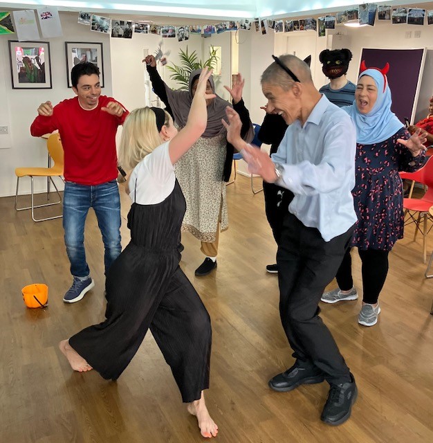 Group of people dancing together in a bright room.