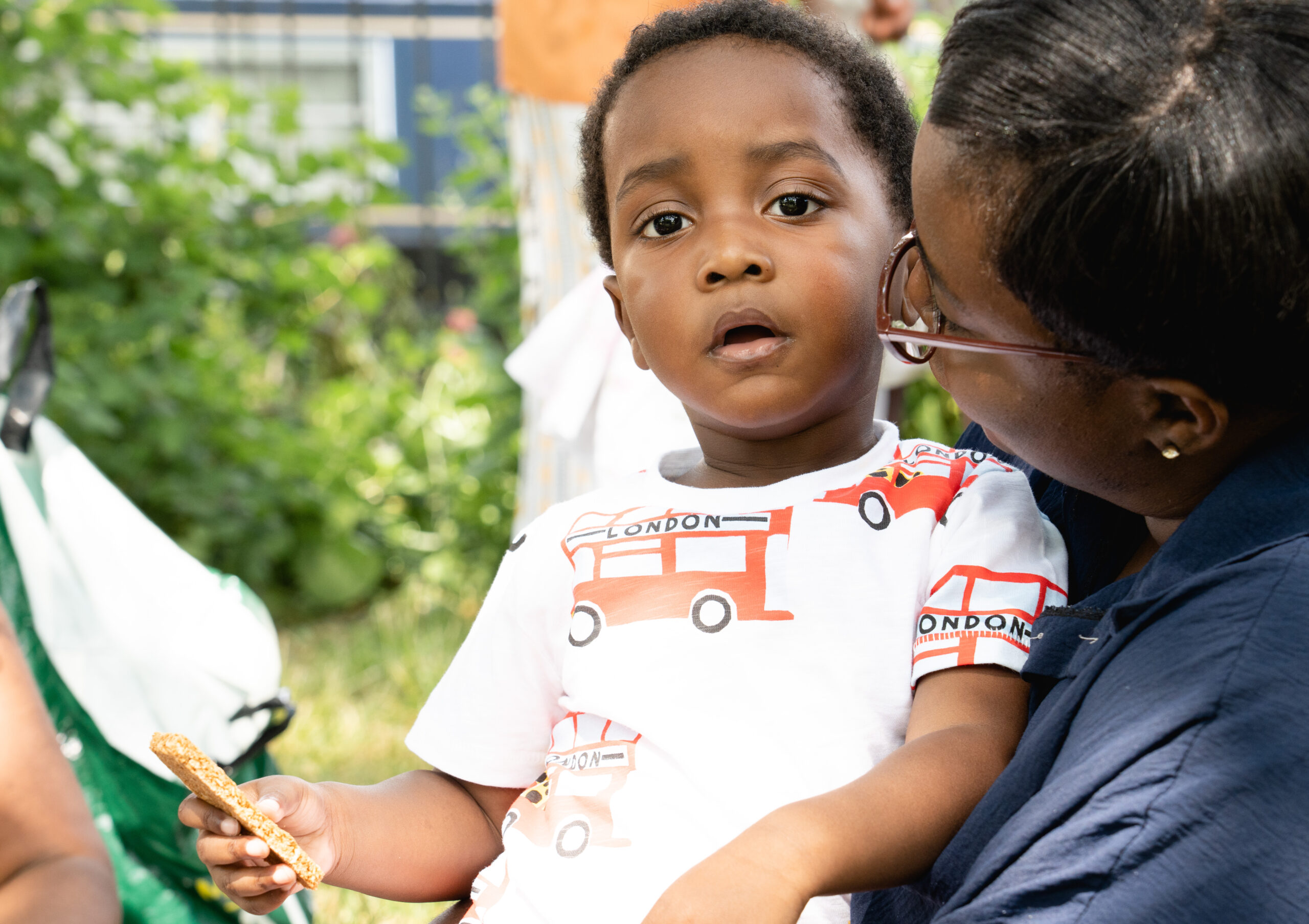 Child sitting on mothers lap looking at the camera
