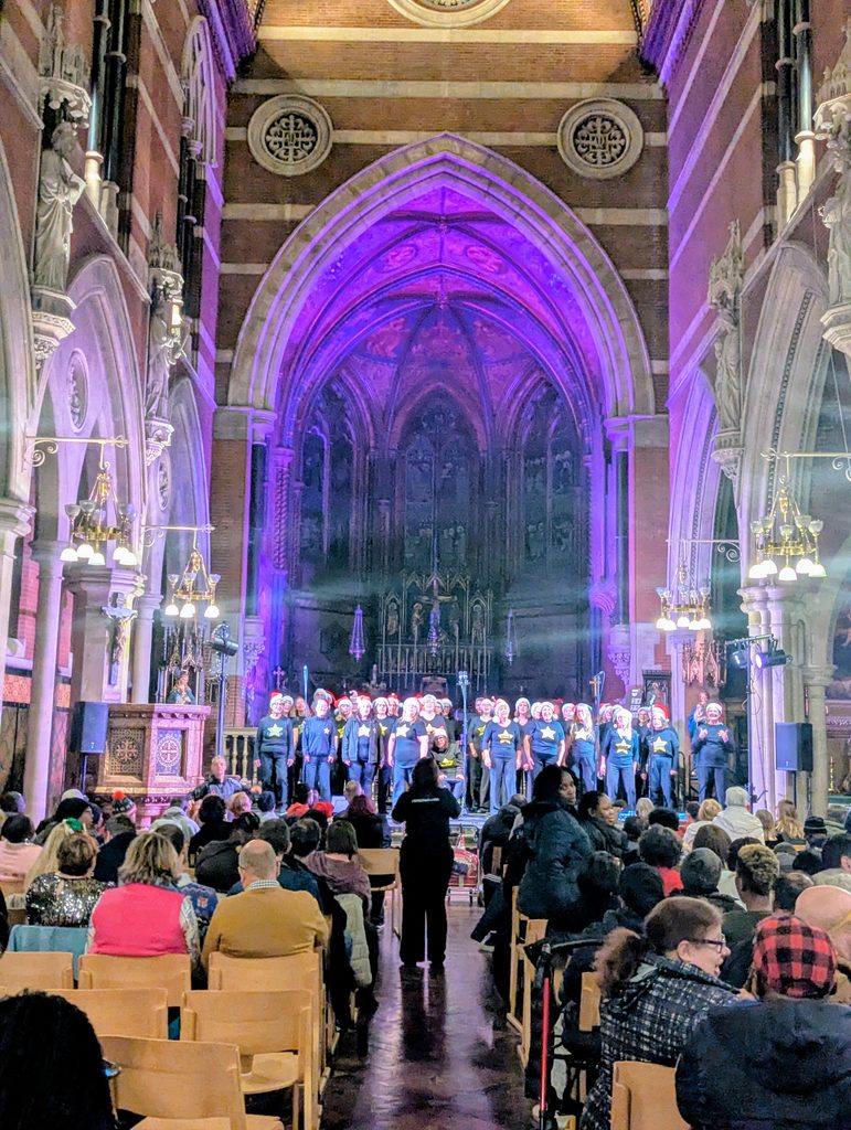The view of the Nave at Grand Junction lit up with up lighters and a crowd of people watching a choir